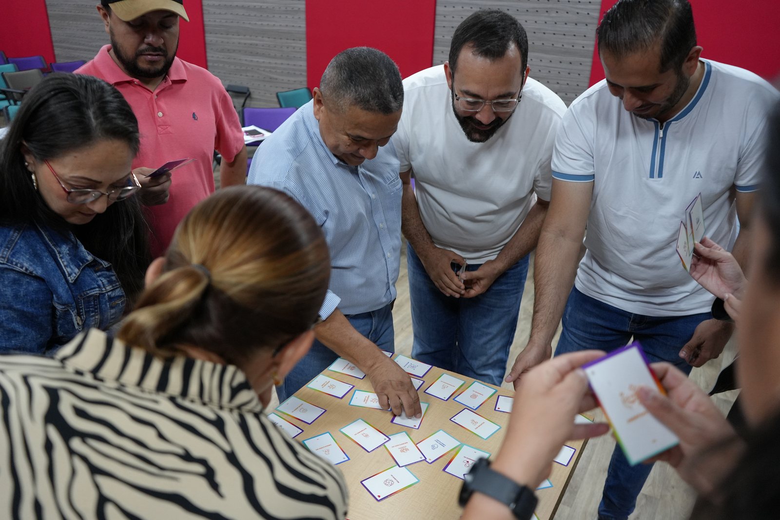 Participantes trabajando con tarjetas sobre la mesa